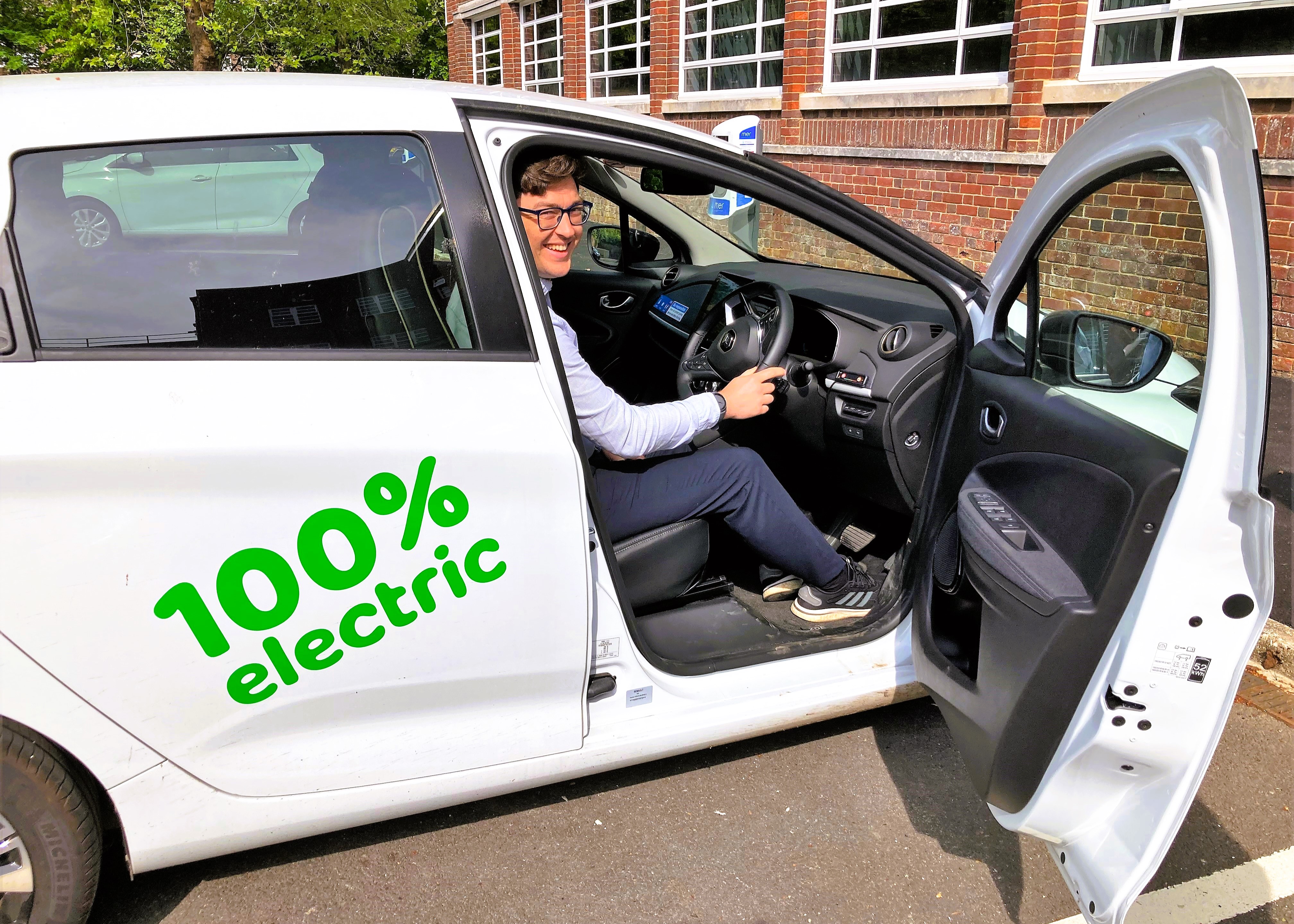 council officer poses for picture in 100% electric council vehicle