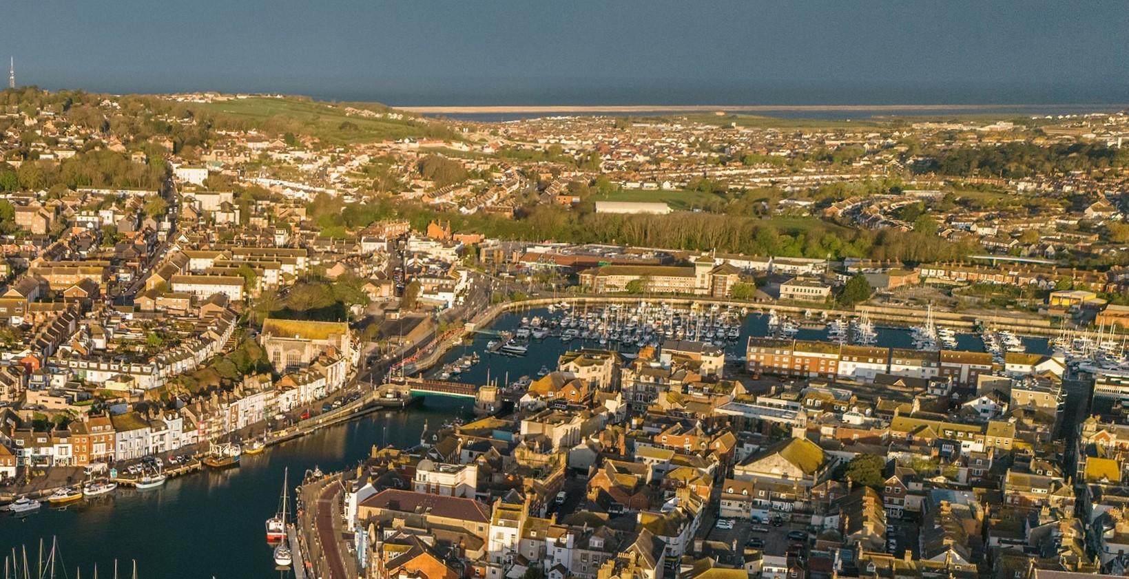 Aerial image of Weymouth Harbour and Marina, looking out to Chesil Beach