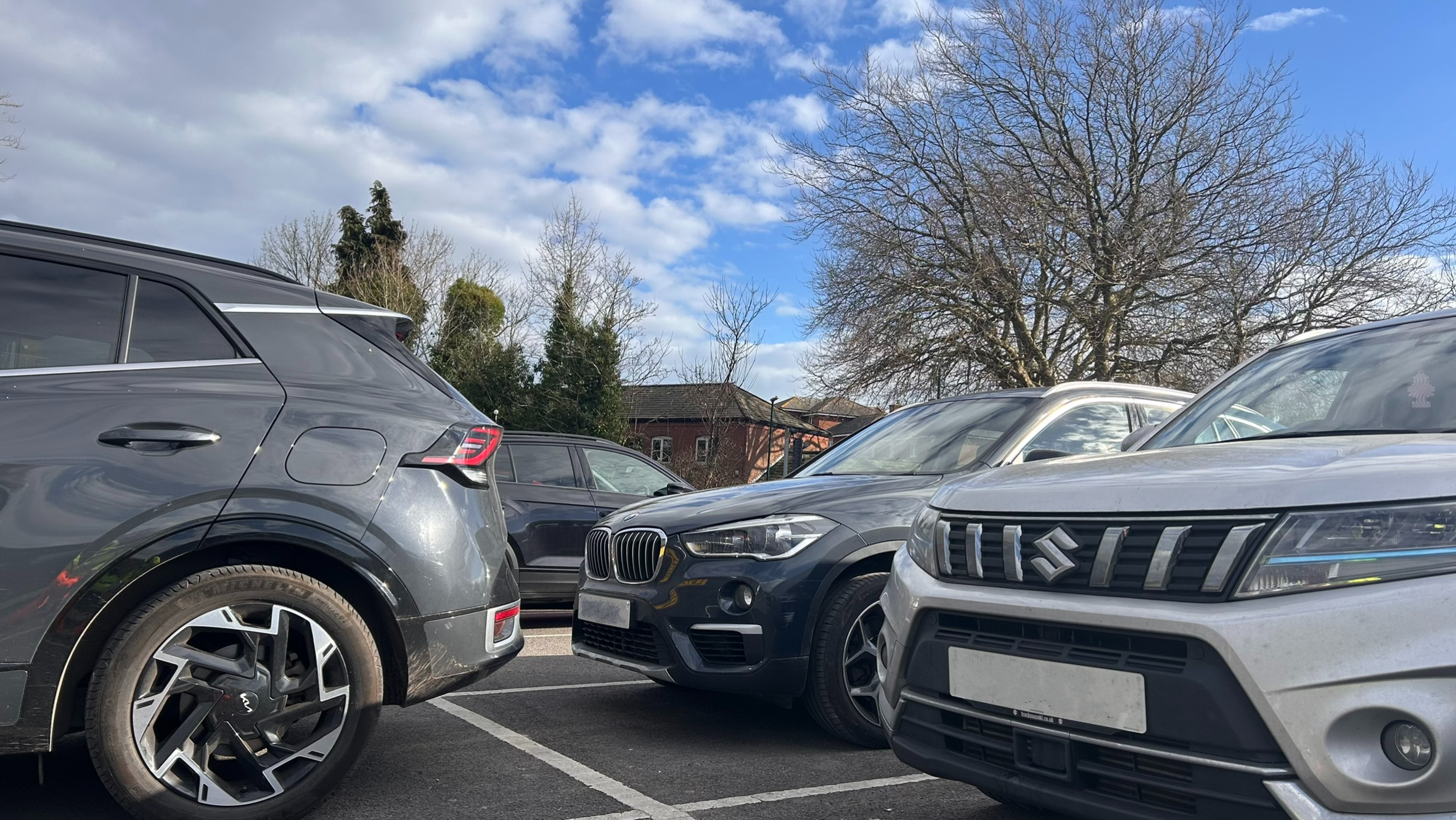 Three parked cars in a car park