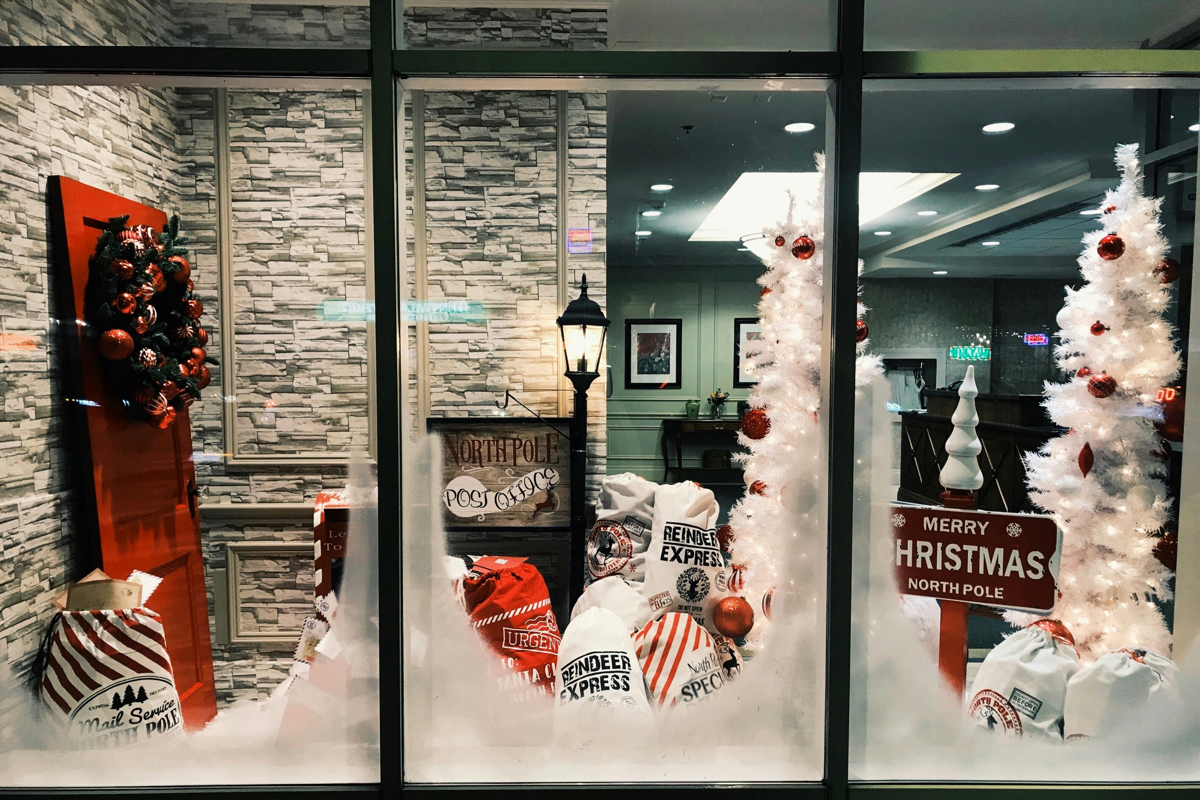 A shop window split into thirds with Christmas parcels and decorations in each third