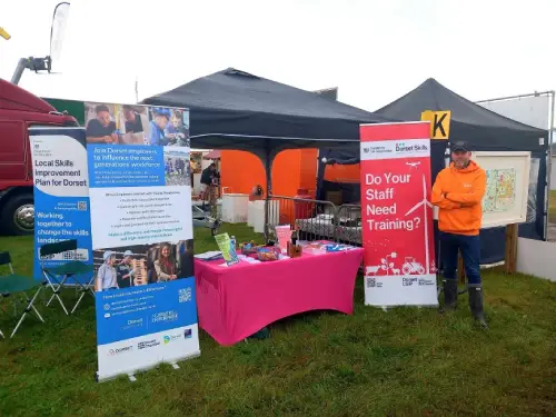 A person standing by the Dorset Skill pop up stall.