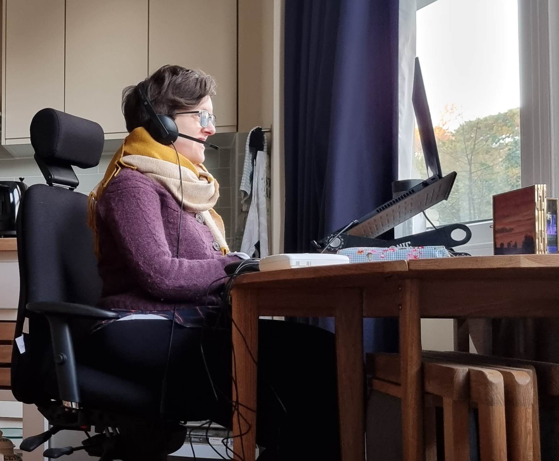 Izzy Pochin sat at a computer desk with a headset on.