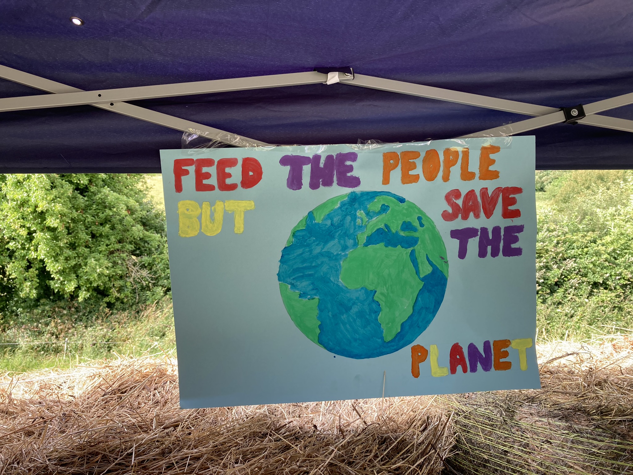 sign that reads "feed the people, save the planet"