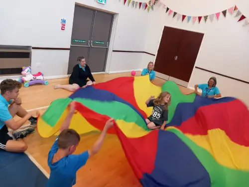 Kids playing the parachute game.