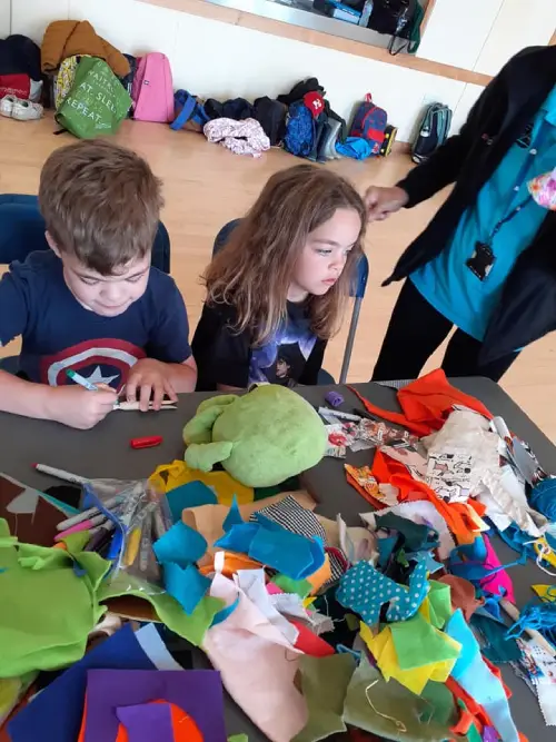 Chrildren sitting in a puppet workshop.