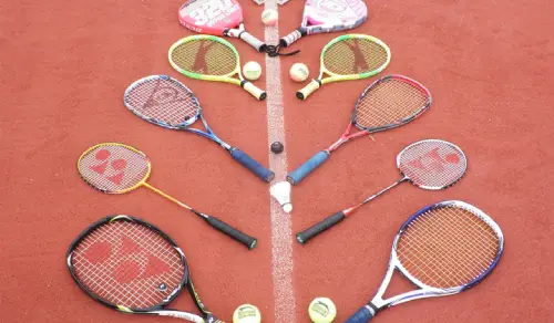 Tennis rackets and tennis balls on the court floor.