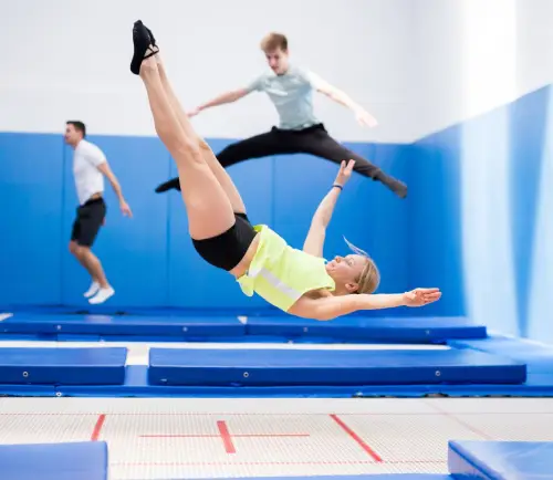 three people jumping on a trampoline.