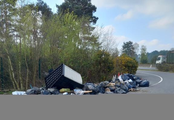 A pile of black bin bags full of rubbish collected from the highway