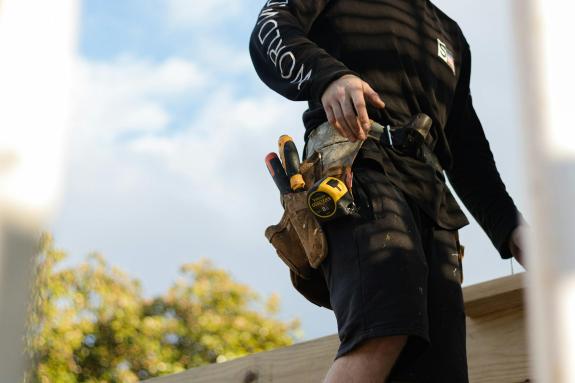 A builder working on a deck ready to lay the next piece of timber